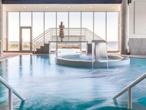 a man standing on a staircase in a swimming pool at Sofitel Quiberon Thalassa sea & spa in Quiberon