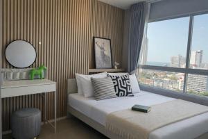 En eller flere senge i et værelse på Lumpini Seaview Jomtien Pattaya Condo 21F