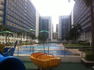 une piscine au milieu d'une ville avec de grands bâtiments dans l'établissement Sea Residences MOA-Eric Apartments, à Manille