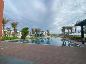a pool at a resort with palm trees and houses at PKseahome 3 bedroom 4 toilet Novaworld in Phan Thiet