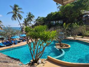 une piscine dans un complexe hôtelier avec des palmiers et l'océan dans l'établissement Crystal Bay Yacht Club Beach Resort, à Lamai