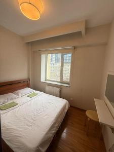 una camera da letto con un letto bianco e una finestra di Eternal Sky Tour & Guest house a Ulaanbaatar