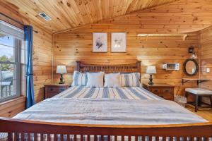 een slaapkamer met een bed in een blokhut bij King Beds, Views, EasyRoads, PoolTable, Spa, Theater, Outdoor fun in Sevierville