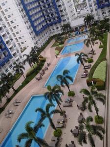 an overhead view of a large pool with palm trees at Sea Residences MOA-Eric Apartments in Manila