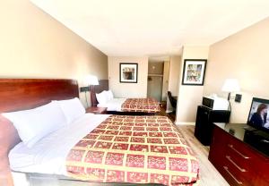 een hotelkamer met twee bedden en een televisie bij Rodeway Inn Jackson Northwest in Jackson