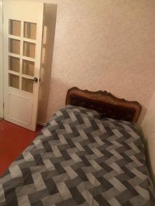 een slaapkamer met een bed met een geruite sprei bij Джермук 3-комнатная квартира in Dzjermoek