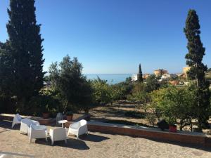 een patio met witte stoelen en uitzicht op de oceaan bij Casa Vacanze Palma in Realmonte