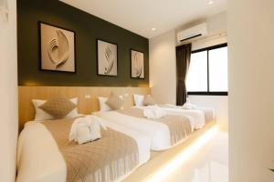 a bedroom with three beds with white sheets at Rivla A Pool Villa in Ao Nang  +26 photos