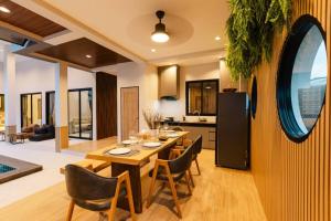 a kitchen and dining room with a table and chairs at Rivla A Pool Villa in Ao Nang 