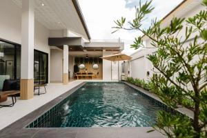 an infinity pool in a villa with a house at Rivla A Pool Villa in Ao Nang 