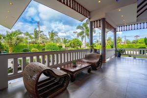 a porch with chairs and a coffee table on a balcony at Phuket La Siesta, Naiharn Beach in Nai Harn Beach +133 photos