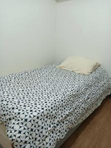un letto sfatto con un piumone bianco e nero di Condo for rent-2 Bedrooms a Lapu Lapu City