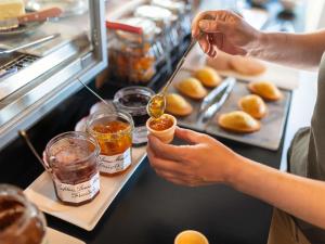 a person is putting honey into a jar of food at ibis Besançon Marchaux in Marchaux +7 photos