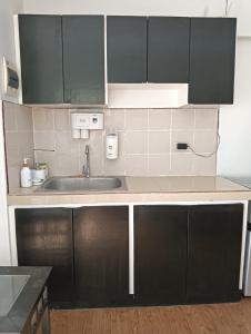 una cucina con armadi neri e lavandino di Condo for rent-2 Bedrooms a Lapu Lapu City