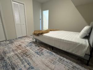 een slaapkamer met een bed met een deken erop bij Luxury 6 Bedroom Home in Denton