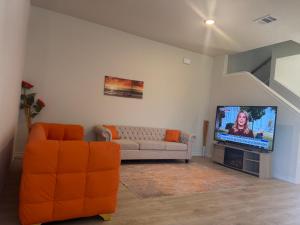 een woonkamer met een bank en een tv bij Luxury 6 Bedroom Home in Denton