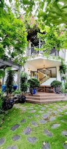 a large white house with a porch and a garden at LumiShora Villa - Bai Truong, Phu Quoc in Phú Quốc