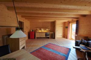 Sala de estar de una cabaña de madera con alfombra en Sonnenplatzl im Zillertal, en Ramsau im Zillertal