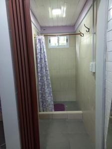 een douche met een paars douchegordijn in de badkamer bij Hostel El Duende Errante in El Bolsón