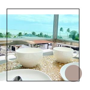 Ein Tisch mit zwei Schalen und Blick aufs Meer in der Unterkunft เดอะซันเซ็ท บางแสน Exclusive Top Floor in Chon Buri + 1 Foto