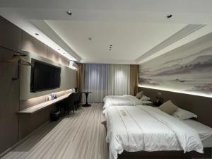a hotel room with two beds and a flat screen tv at Ancient City District Ai Shan Hotel in Lijiang +26 photos