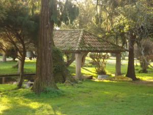 a wooden gazebo in a park with trees at Pazo a Capitana in Cambados