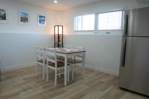 een keuken met een tafel, stoelen en een koelkast bij Sunny Suite in Saskatoon +2 foto's