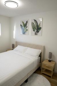 een slaapkamer met een bed en twee schilderijen aan de muur bij Sunny Suite in Saskatoon