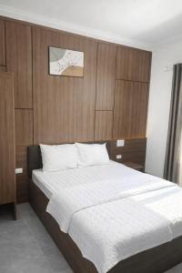 een slaapkamer met een groot bed met een houten hoofdeinde bij Visip Hotel in Vinh