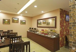 a bar in a restaurant with a table and chairs at Hotel Grand Suites - Delhi Airport By Dcapitol in New Delhi