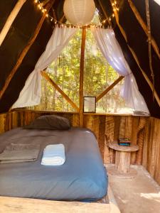 a mattress bed in a tent with a window at Eco Farmstay near Corozal Belize Quiet Nature Stay in Corozal