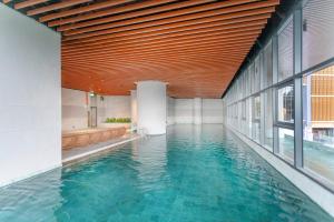 云顶高原Antara Genting Highlands by COBNB - near Link Bridge的一座带木制天花板的建筑中的游泳池