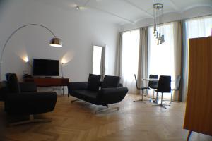 a living room with chairs and a table and a television at M M Central 70's Style in Berlin