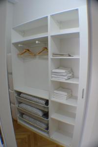 a white closet with white shelves and towels at M M Central 70's Style in Berlin