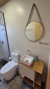 ein Badezimmer mit Waschbecken und Spiegel an der Wand in der Unterkunft Apartamento Loft Terreo in Videira