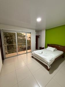 una camera da letto con una parete verde e un letto di HOTEL VILLAREAL VILLAVICENCiO a Villavicencio