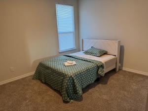 a bedroom with a bed with a blanket and a window at Luxury 12 Bedroom Villa in Denton