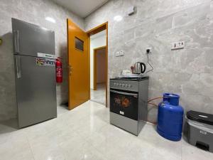 eine Küche mit Herd und Kühlschrank in der Unterkunft Furnished 2BR Central Al Ain in al-Ain + 27 Fotos