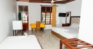 ModakandiyaFlamingo Lake Resort Tissamaharama的一间带两张床的卧室和一间带桌子的餐厅