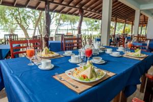 ModakandiyaFlamingo Lake Resort Tissamaharama的一张带食物和饮料盘的蓝色桌子