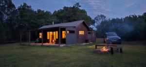 een auto geparkeerd voor een tiny house bij Pura Vida Forest Cabin in Witelsbos