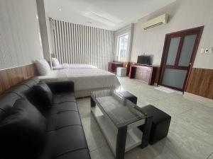 ein Hotelzimmer mit einem Bett und einer Couch in der Unterkunft Orova Hotel in Ấp Phú Thọ