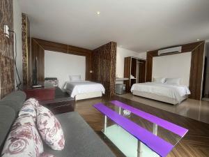 ein Wohnzimmer mit zwei Betten und einem lila Tisch in der Unterkunft Orova Hotel in Ấp Phú Thọ