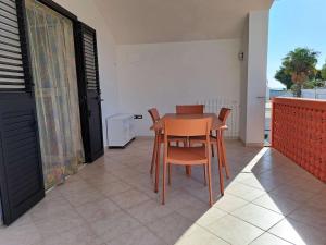 un tavolo con sedie in una camera con balcone di Villa Vieste a Vieste