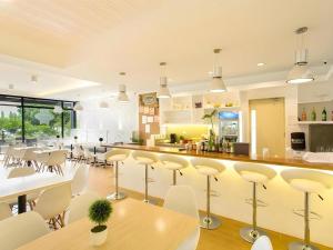 una cucina con un bar con sedie e tavoli bianchi di Venue 88 a Dulongabong