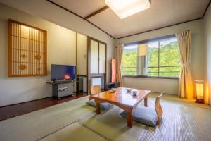 un soggiorno con un tavolo e una televisione di KKRzaoHakuginso a Yamagata