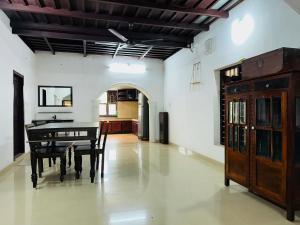a dining room with a table and a kitchen at HARSHAM Eco Village in Puthuppādi