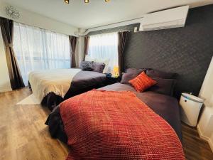 a bedroom with two beds and a window at Shimokitazawa Cozy Apartment 401 in Tokyo