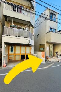 a yellow arrow pointing to a building at Shimokitazawa Cozy Apartment 401 in Tokyo