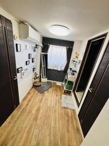 a living room with a wooden floor and a window at Shimokitazawa Cozy Apartment 401 in Tokyo